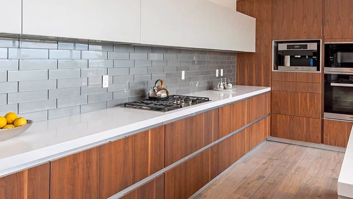 Walnut wood-slab kitchen cabinetry with white quartz countertops, a gray glass-tile backsplash, a gas cooktop, and built-in wall ovens