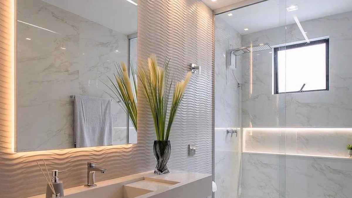 Modern bathroom with a floating vanity, a backlit mirror, a textured wave-pattern feature wall, and a glass shower enclosure